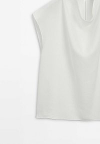 Haut blanc sans manches avec un col rond, présenté sur fond blanc.