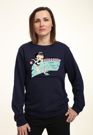 Marineblå sweatshirt med et retro tegnefilmsdesign af en karakter med sort hår i flapperstil, der promoverer "Boop-O-Matic Electric Vacuum Cleaner."