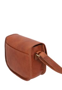 Lille brun læder crossbody taske med synlige syninger og justerbar rem fastgjort med metalring.