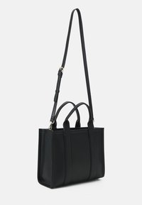 Sac fourre-tout en cuir noir avec poignées doubles et une bandoulière détachable, présentant un design structuré et des détails de couture verticale.