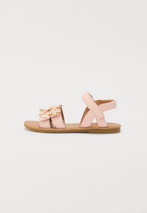 Sandali in pelle rosa con applicazioni floreali, cinturini regolabili, suola piatta e soletta color sabbia. Design aperto per una buona traspirabilità.