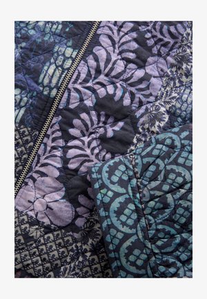 Quilted textile featuring a mix of floral and geometric patterns in deep navy and purples, with a metallic zipper for closure.