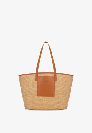Sac fourre-tout avec corps en paille tissée, anses en cuir marron et une patte avant assortie en cuir avec un petit logo en métal.