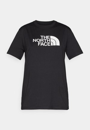 T-shirt en coton noir avec un grand logo blanc "THE NORTH FACE" sur la poitrine et un col rond. Manches courtes, coupe décontractée.