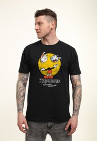 Schwarzes Baumwoll-T-Shirt mit einem Grafikdruck von Cartoonfiguren auf einem gelben Kreis, mit roten Akzenten und dem Text "Cuphead: The Delicious Last Course."