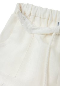 Shorts di lino color crema con vita elasticizzata, dettaglio con cordoncino e tasche laterali. Tessuto morbido e leggero.