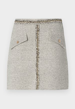 Audimas pintas tweed sijonas baltai juodai su žuvų kaulų raštu, turi dvi priekines kišenes ir auksinės spalvos užtrauktuką gale su nusidėvėjusiais kraštais.
