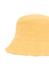 Gul frottéhatt i en texturerad, vågig design; bred, lutande brätte och mjukt, plyschmaterial.