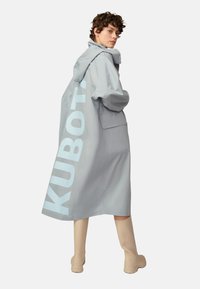 Helle graue wasserdichte Jacke mit Kapuze, ausgestattet mit einem großen "KUBOTA"-Druck in Hellblau an der Seite und einer einzelnen aufgesetzten Tasche.