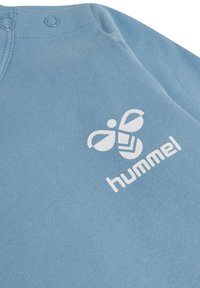 Lichtblauwe katoenen sweatshirt met witte bedrukte logo en accenten. Inclusief drukknoopsluitingen bij de hals voor eenvoudig aankleden.