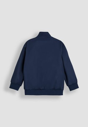 Marineblauwe bomberjack met een hoge kraag, elastische manchetten en zoom, een gladde matte afwerking en zonder zichtbare ritsen of zakken.