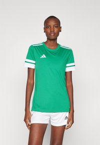 Groene sporttrui met witte accenten, voorzien van een ronde hals, korte mouwen en drie horizontale witte strepen op de mouwen.