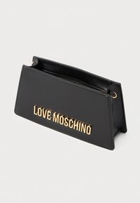 Black trapezoid leather clutch with gold "LOVE MOSCHINO" lettering and a zipper top closure.