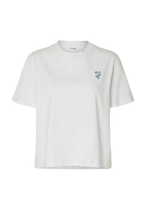 Witte katoenen t-shirt met een ronde hals, korte mouwen en een kleine lila bloemvoering op de linkerborst. Ontspannen pasvorm, gladde textuur.