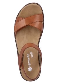 Sandale en cuir marron avec un design à bandes croisées, semelle texturée et marquage "remonte soft" sur la semelle intérieure. Accents cousus sur les bords.