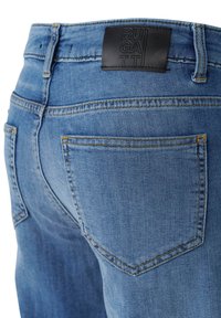 Blue denim jeans with a straight design, featuring yellow stitching and a black leather patch labeled "BUGATTI" at the waistband.