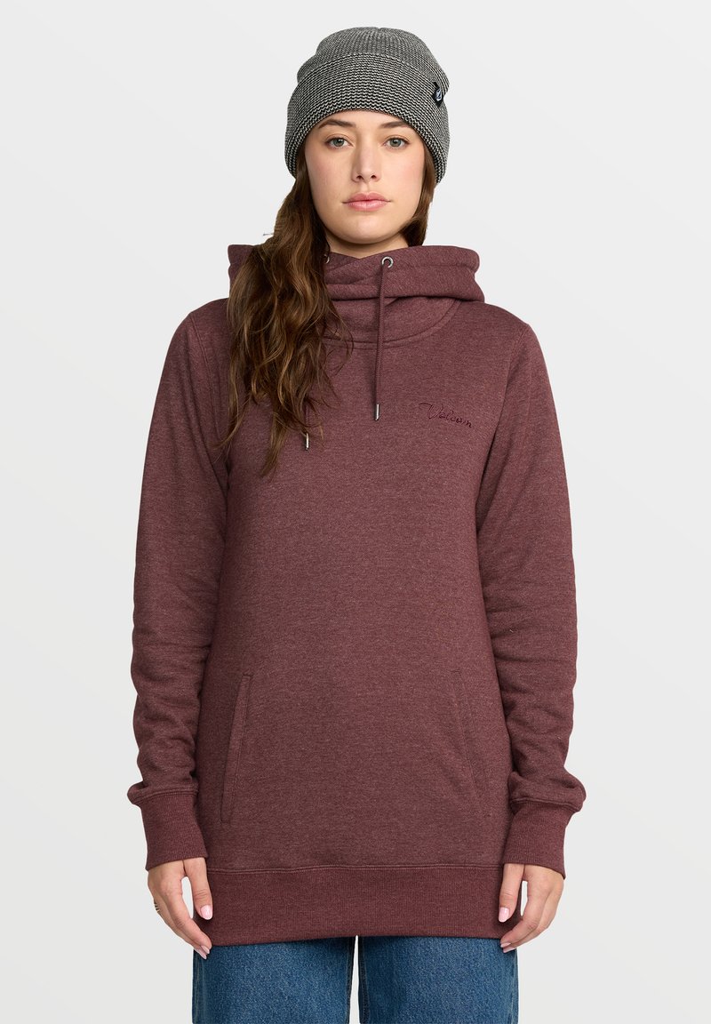 Sweat à capuche bordeaux avec un col montant, un cordon de serrage et des poches latérales. Présente des poignets et un ourlet côtelés, associé à un bonnet en tricot gris.