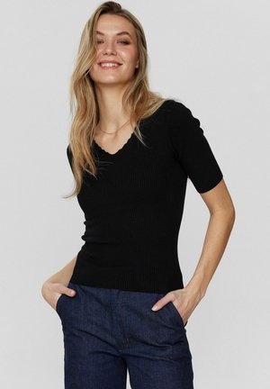 Top corto a maniche corte nero a coste con scollatura a V ondulata. Design aderente, texture liscia, abbinato a pantaloni in denim scuri.
