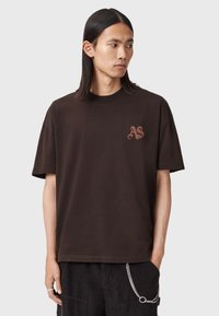 Brązowy bawełniany t-shirt z krótkimi rękawami i okrągłym dekoltem, z małym haftowanym logo "AS" na lewej piersi.