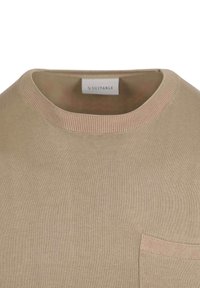Beige gebreid T-shirt met een ronde halslijn, voorzien van een pocket en contrasterende ribbeldetails bij de kraag en zoom. Glad van structuur.