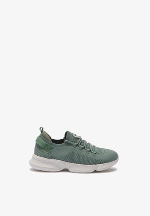 Baskets en tricot vert clair avec semelle blanche épaisse, lacets à l'avant et languette à l'arrière, présentées de profil sur fond blanc.