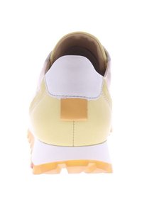 Sneaker in runder Form, hauptsächlich gelb mit weißen und grauen Akzenten. Verfügt über ein strukturiertes hinteres Panel und einen goldenen Tab. Gummisohle.