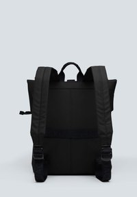Mochila negra con acabado mate, que cuenta con correas de hombro acolchadas y un asa superior. Incluye una correa de marca en la parte posterior.