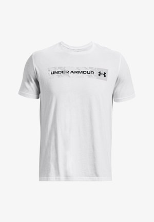 Camiseta blanca de algodón con un logo negro de "UNDER ARMOUR" sobre un fondo gris de camuflaje en el pecho. Mangas cortas y cuello redondo.