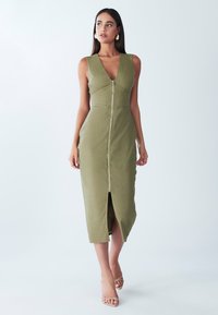 Olivi vihreä hihaton mekko, jossa on syvä V-pääntie ja etuvetoketju, etuhalkio, tiukka malli ja pehmeä tekstuuri.
