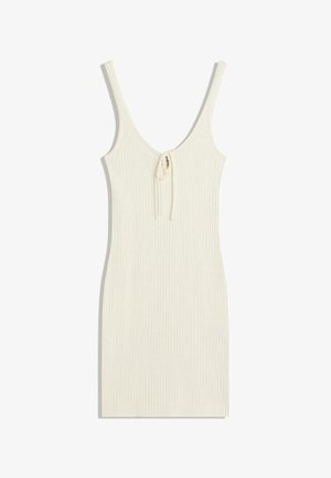 Ribbede cremede kjole med tynde stropper og dyb V-hals. Har en bindedetalje foran. Glat tekstur og tætsiddende silhuet.