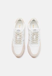 Weiße Sneakers mit beigen Akzenten, aus Leder und Wildleder gefertigt. Merkmale sind abgerundete Zehen, Schnürdesign und eine strukturierte Sohle.