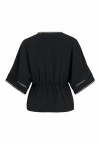 Blouse noire avec manches larges, taille froncée et délicate dentelle sur l'encolure et les bords des manches.
