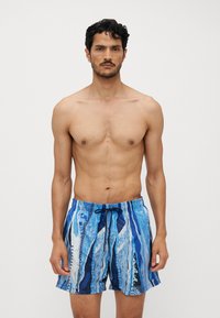Blue patterned swim shorts with a drawstring waistband, featuring various shades of blue and white in a vibrant, abstract design.