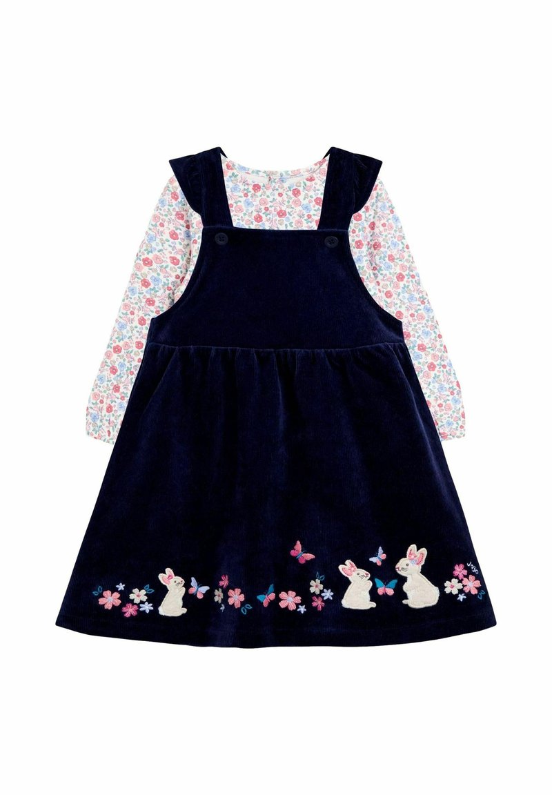 Túnica de pana azul marino con conejitos, mariposas y flores bordados, combinada con una camisa de manga larga con estampado floral.