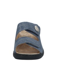 Blue open-toe sandal with cross straps, made from textured material. Features a black sole and a decorative silver button accent.