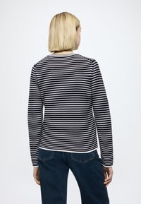 Haut à manches longues avec rayures bleu marine et lignes horizontales blanches, col arrondi et coupe ajustée. Le tissu semble doux avec une texture fine.