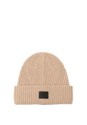 Bonnet en tricot de couleur beige clair avec une texture côtelée et un revers. Présente une étiquette rectangulaire noire à l'avant.