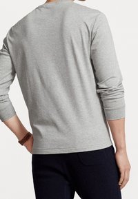 Grå långärmad skjorta i bomullsblandning, med rundad halsringning, ribbade mudd och en avslappnad passform, sedd bakifrån.