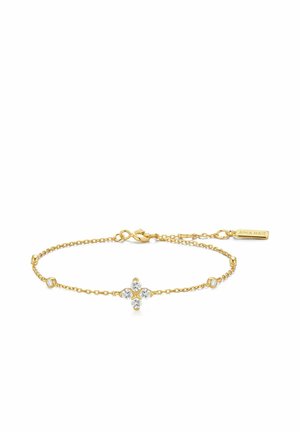 Fin guldkædearmbånd med en central korsformet klynge af fire klare ædelsten og to mindre ædelsten på hver side.