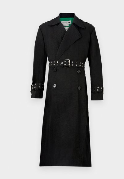Schwarzer Trenchcoat mit strukturierter Oberfläche, doppelreihiger Front, breiten Revers und tailliertem Design mit silbernen Ösen an den Manschetten.