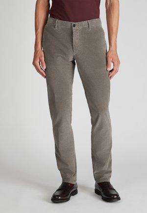 Grijze ribfluwelen broek met verticale ribbelstructuur, voorzien van een voorste knoopsluiting en zakken. Draagt met donkere schoenen, wat een op maat gemaakte pasvorm toont.