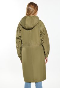 Long olive green raincoat with a hood, elastic cuffs, and a cinched waist, made from a smooth, lightweight material.
