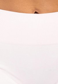 Jasnoróżowy sportowy pas z prążkowaną teksturą, w zestawieniu z gładkim białym materiałem poniżej. Zbliżenie na materiał i kształt.