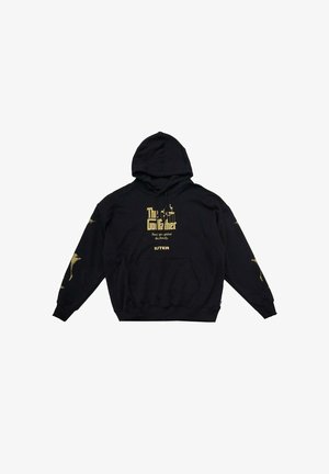Felpa con cappuccio nera in cotone, caratterizzata da testo e dettagli dorati. Include una tasca frontale e polsini a costine. I punti salienti del design comprendono grafiche sulle maniche.