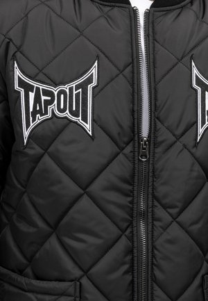 Melnā kviltotā bomber jaka ar TAPOUT logo uzlīmēm. Iespējas ar norauto priekšu un divām sānu kabatām ar gludu tekstūru un izturīgu materiālu.