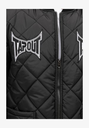 Melnā kviltotā bomber jaka ar TAPOUT logo uzlīmēm. Iespējas ar norauto priekšu un divām sānu kabatām ar gludu tekstūru un izturīgu materiālu.
