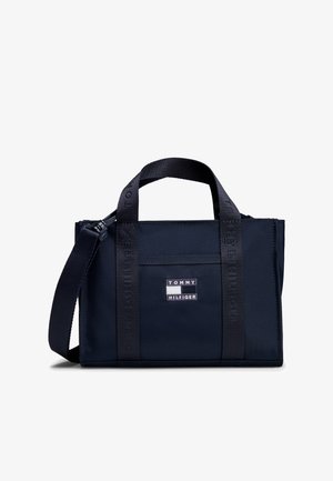 Mała granatowa torba typu tote Tommy Hilfiger z podwójnymi krótkimi uchwytami, odpinanym paskiem na ramię i naszywką z logo na przodzie.