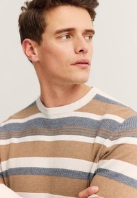 Dzianinowy sweter z poziomymi paskami w odcieniach beżu, bieli i niebieskiego. Okrągły dekolt z ryżowym splotem i gładkim wykończeniem.