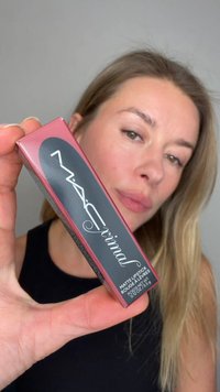 Rouge à lèvres mat MAC dans un emballage rectangulaire bordeaux avec un accent noir et un logo blanc ; détails de l'étiquette visibles ; tenu dans une main.