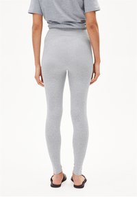 Gray leggings made of stretchy fabric, featuring a high waistband and a fitted silhouette, extending to the ankles with a smooth texture.